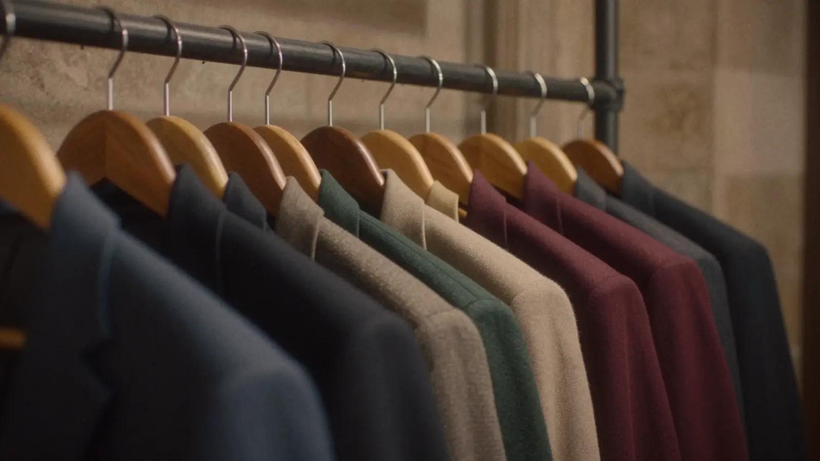 Rij colberts op houten hangers in marineblauw, beige, groen en bordeaux