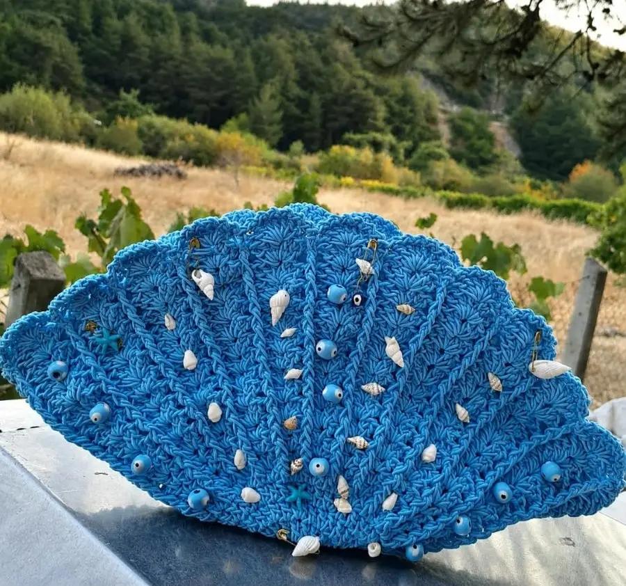 Gehaakte schelpvormige clutch in blauw met schelpjes