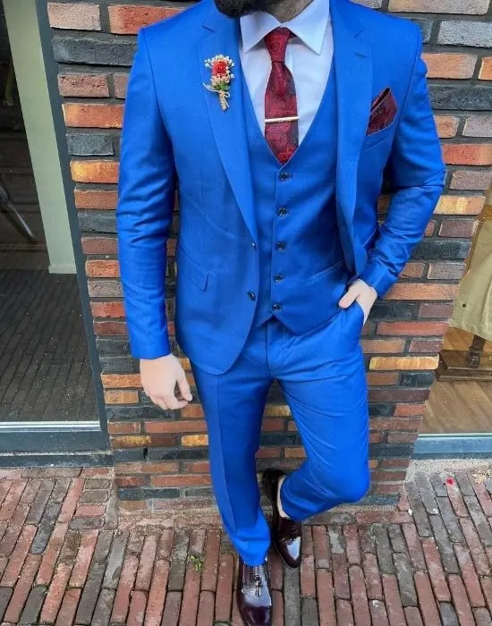 Homme en costume bleu vif avec cravate rouge