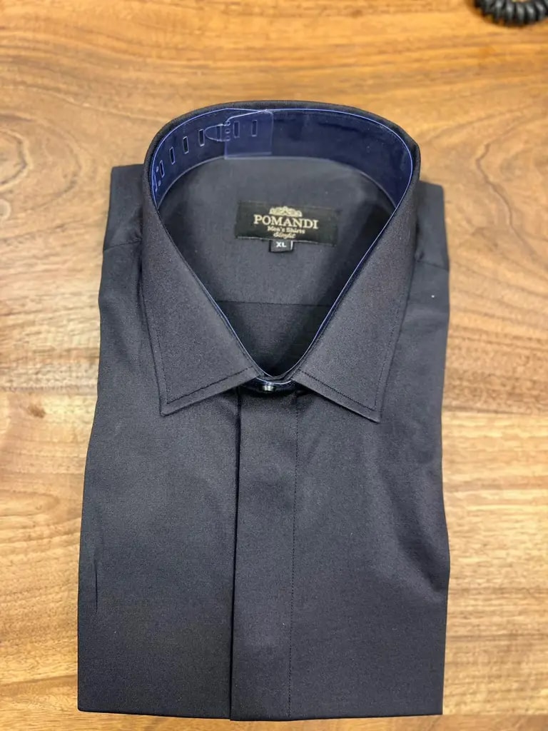 Chemise noire élégante pliée sur une table en bois