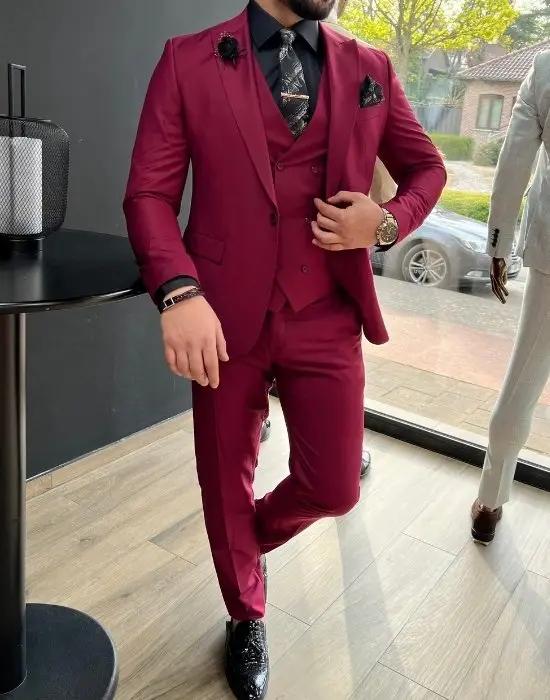 Homme en costume bordeaux élégant avec cravate.