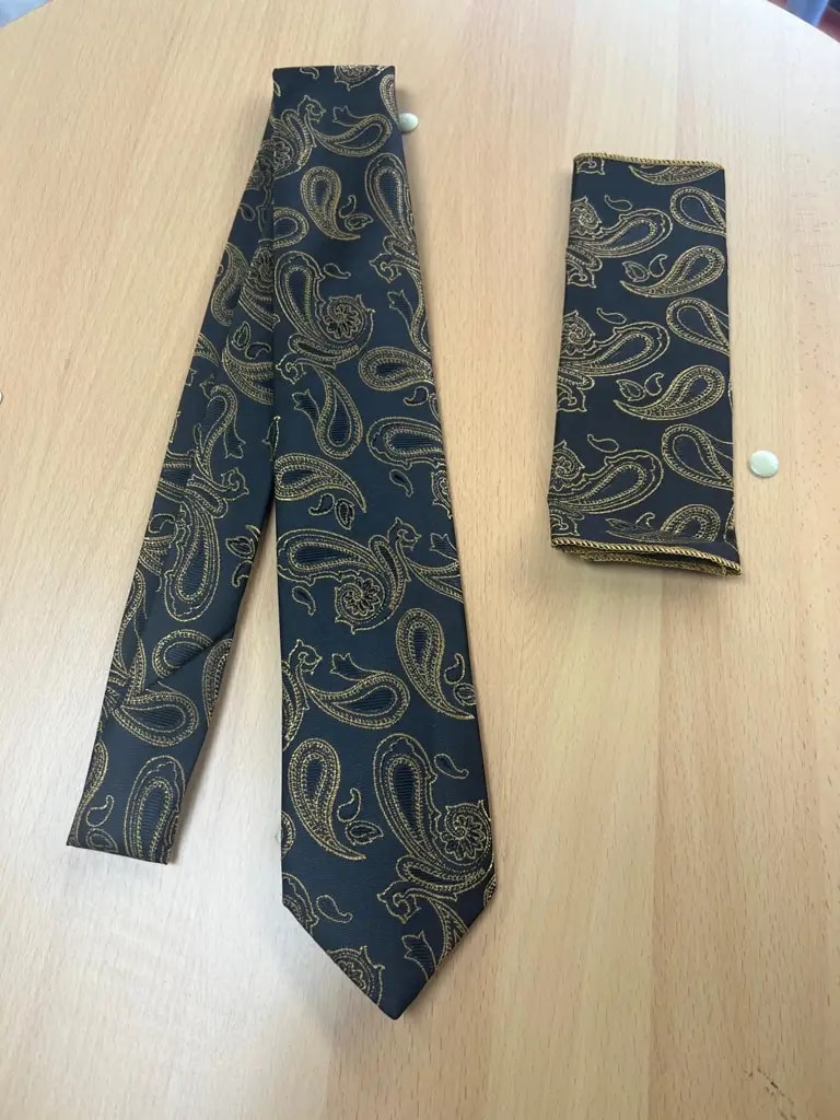 Cravate et pochette à motifs paisley dorés sur fond noir