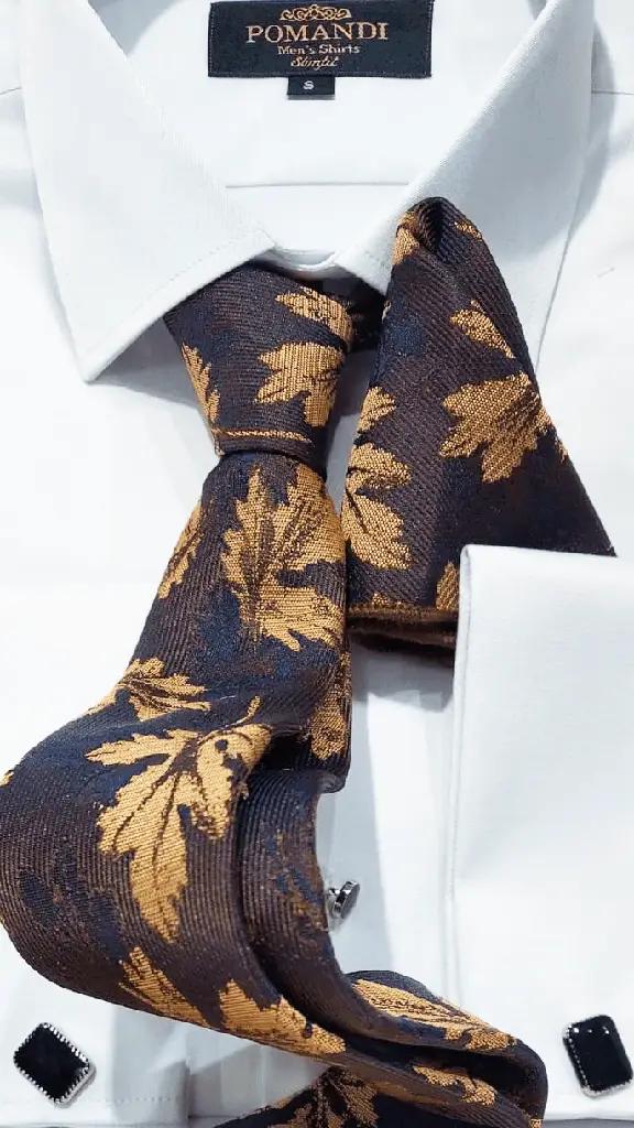 Chemise blanche avec cravate à motifs feuilles dorées