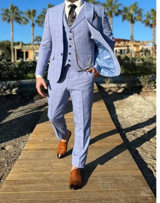 Homme en costume élégant bleu clair sur une promenade en bois