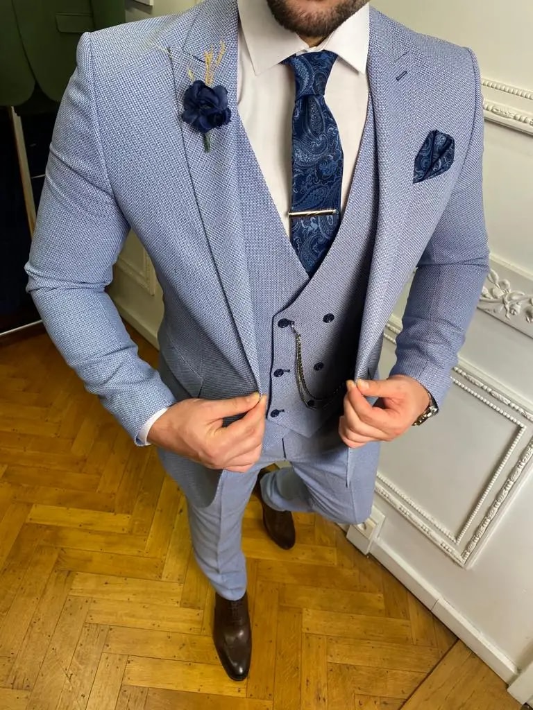 Homme portant un costume trois pièces bleu avec cravate