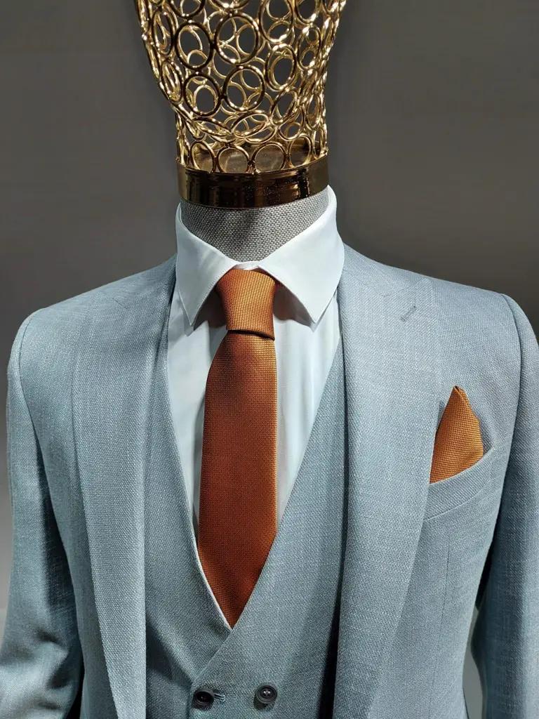Costume trois pièces gris clair avec cravate orange