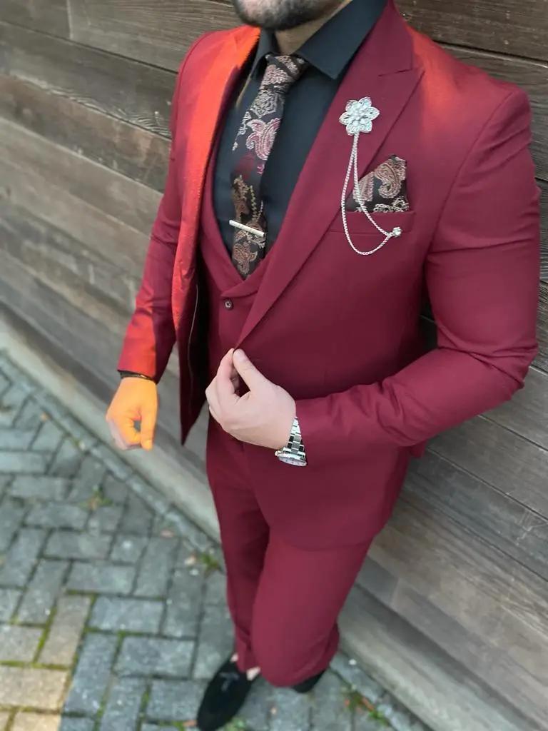 Homme en costume trois pièces bordeaux avec accessoires élégants