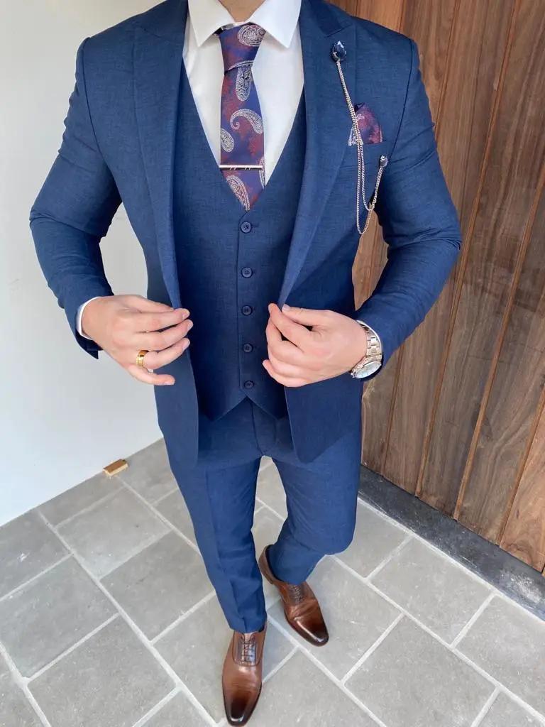 Homme portant un costume bleu avec cravate à motifs.