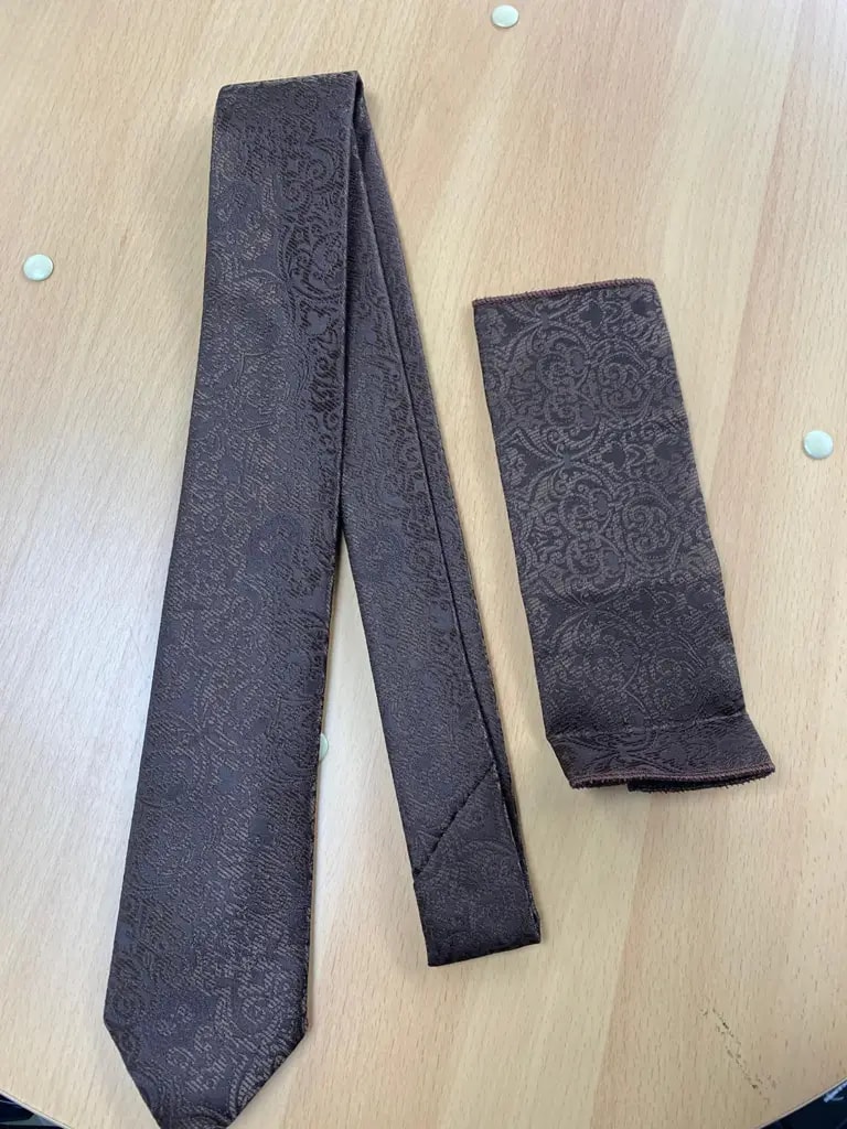 Cravate et pochette marron en soie avec motif cachemire.