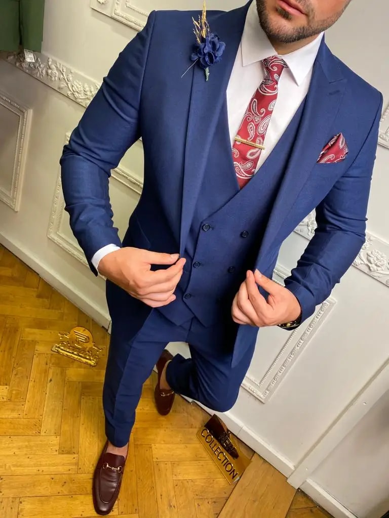 Homme en costume bleu avec cravate rouge à motifs