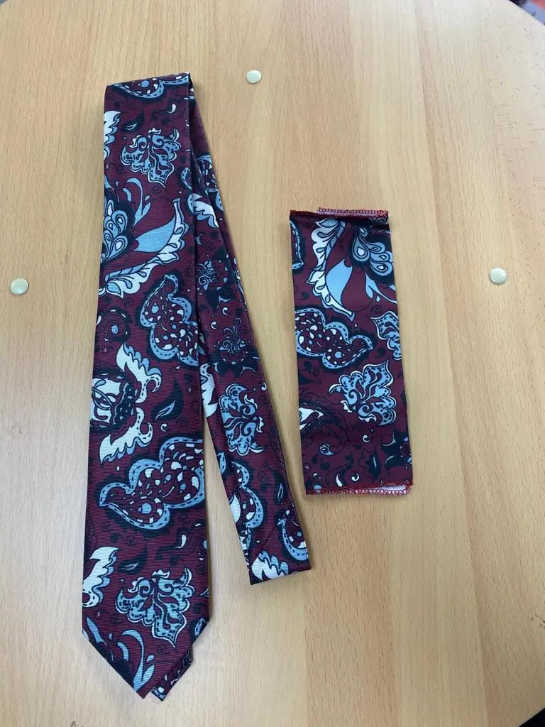 Cravate et pochette à motifs floraux sur fond en bois
