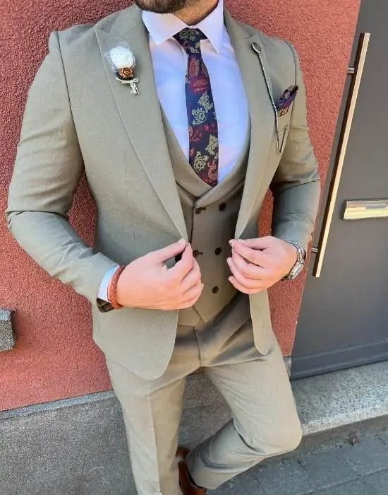 Homme en costume trois pièces beige avec cravate fleurie